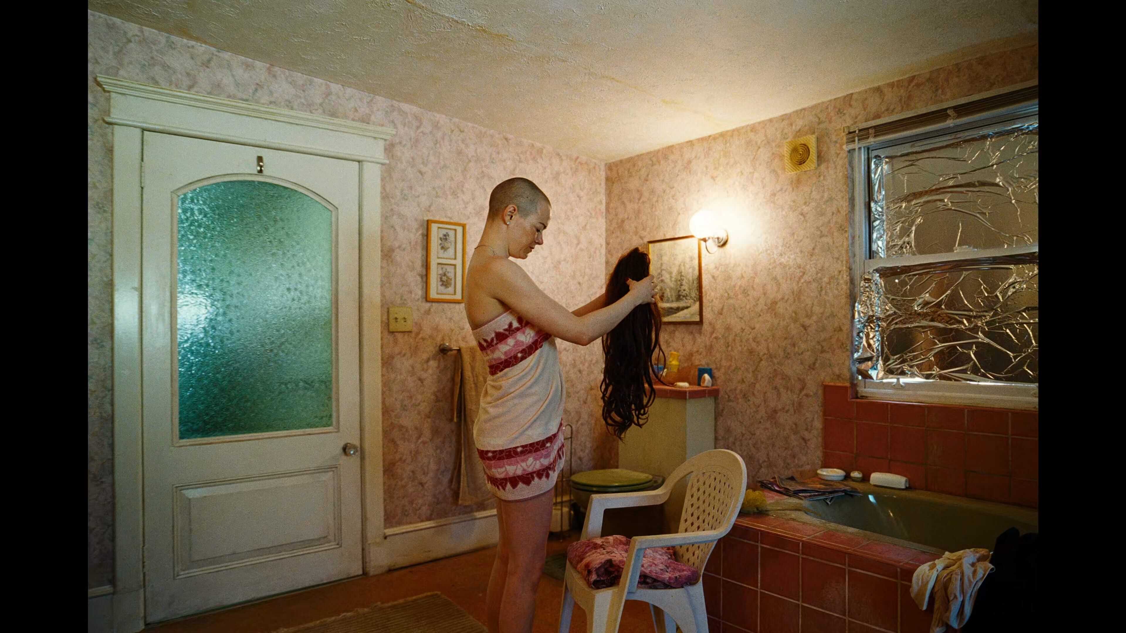 обритая налысо женщина примеряет парик