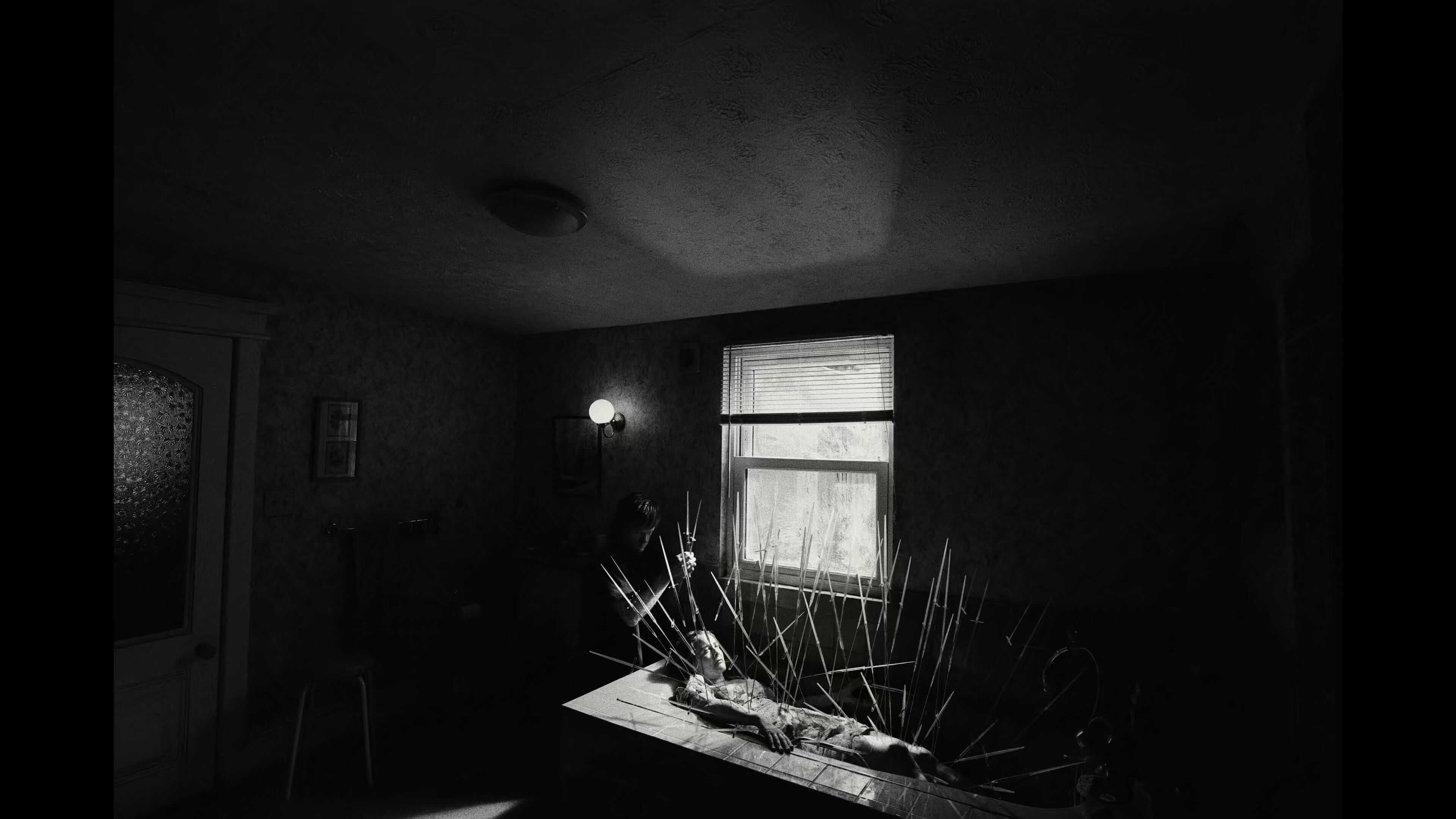 Черно-белое фото женщины, проткнутой иглами