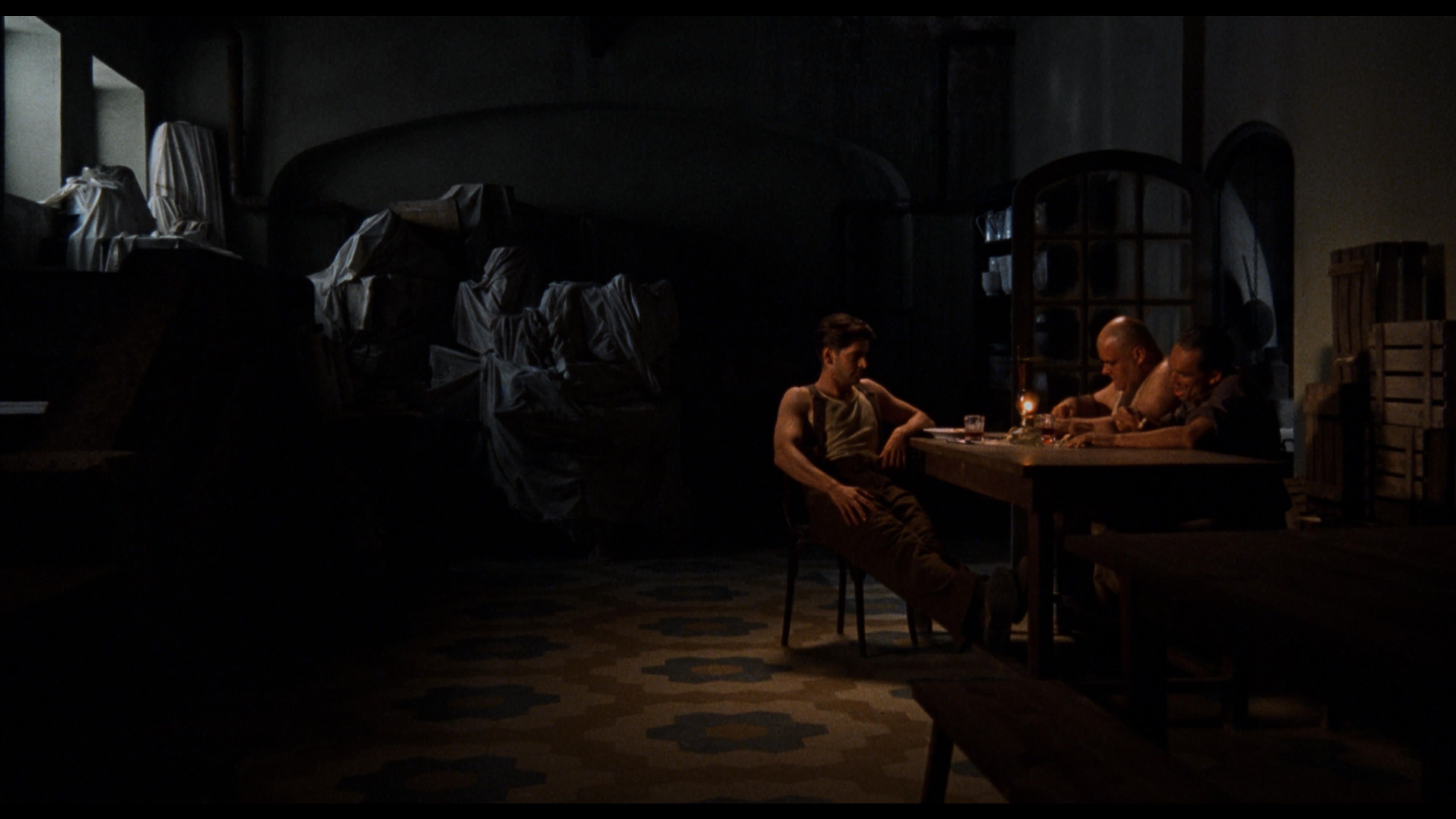 мужчины сидят за столом в темноте