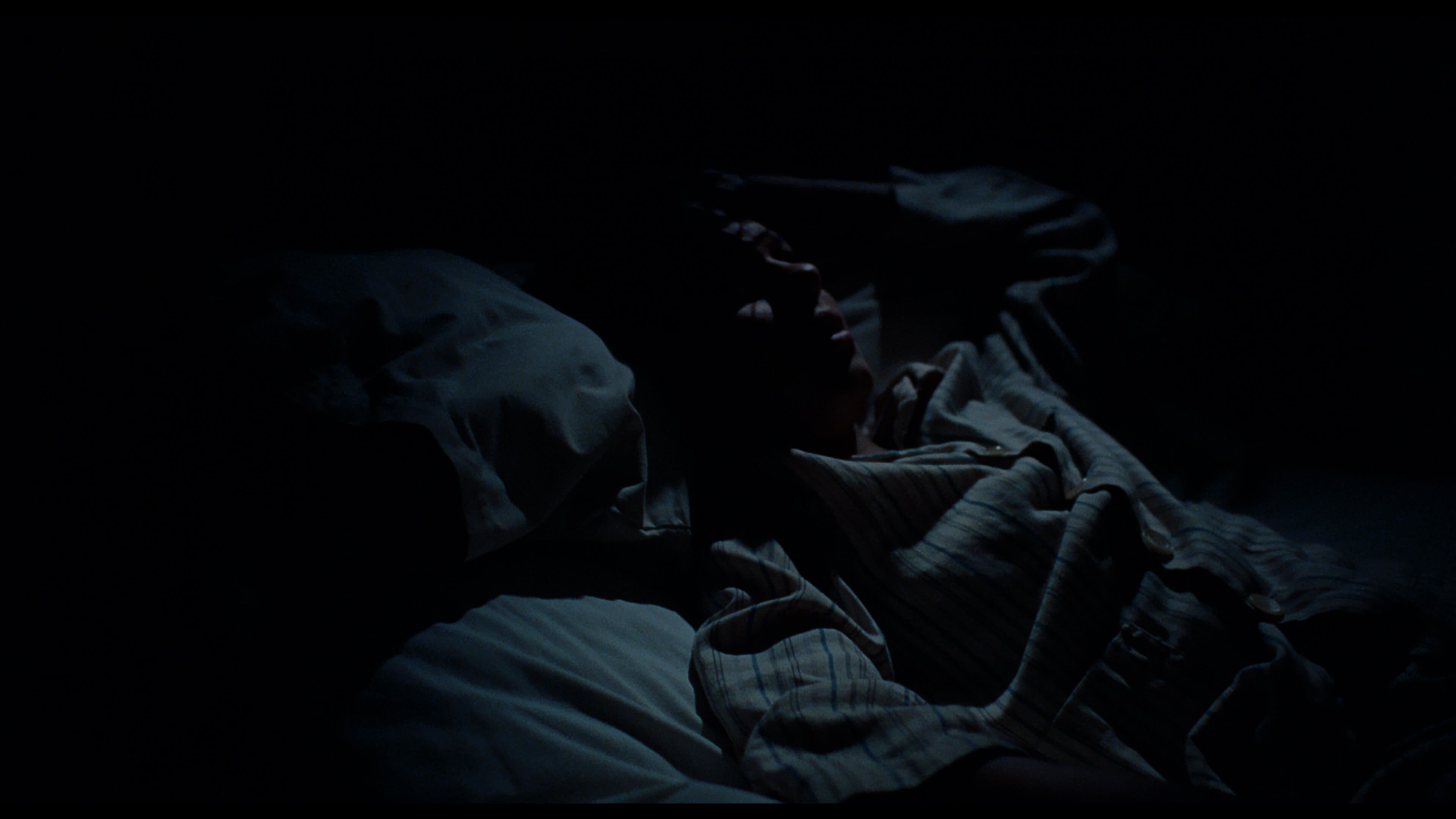 мальчик лежит на кровати в темноте